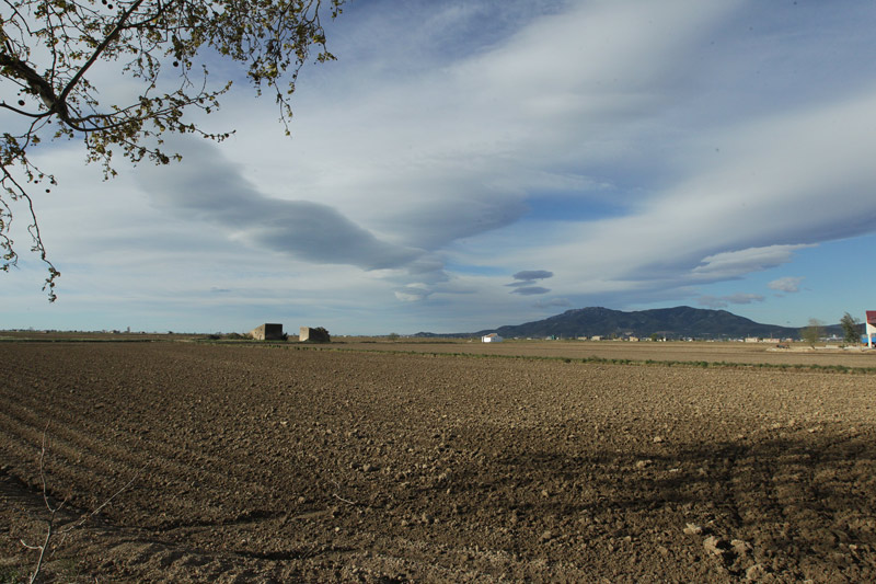 Núvol, al fons la serra del Montsià.